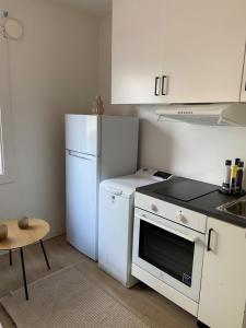 uma cozinha com electrodomésticos brancos e um frigorífico branco em Liten koselig hybel i Gamle Oslo em Oslo