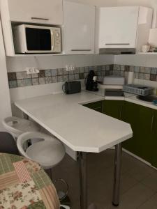 uma cozinha com um balcão branco e um micro-ondas em Éva apartman em Balatonboglár