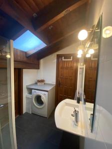 a bathroom with a sink and a washing machine at Ático en Llivia in Llivia