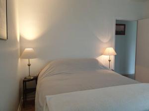 een slaapkamer met een bed met twee lampen erop bij Maison à Roscoff à 150 m de la thalasso et des plages in Roscoff