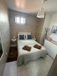 聖特奧托紐的住宿－Alojamento Amor de Mãe，一间卧室配有两张带蓝色枕头的床。