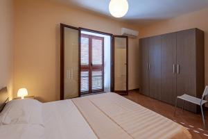 Gratteri Holiday Appartamento Rapi Pitittu في Gratteri: غرفة نوم بسرير كبير ونافذة كبيرة