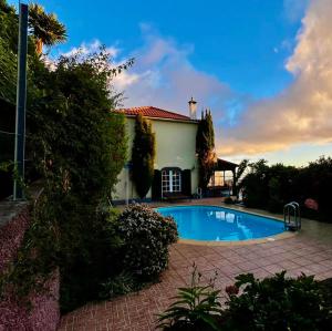 a house with a swimming pool in the yard at Blooming Botanic Houses in Estreito da Calheta