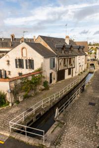 eine Brücke über einen Kanal in einer Stadt mit Gebäuden in der Unterkunft Le Relais Des Templiers in Beaugency