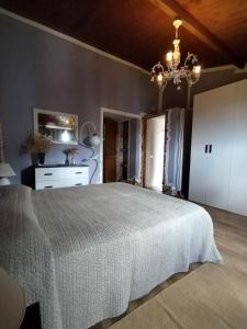 a bedroom with a bed and a chandelier at Grace House in Cuglieri