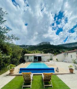 a villa with a swimming pool and two chairs at Studio de charme avec piscine in Fontaine-de-Vaucluse