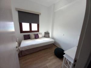 a small bedroom with a bed with a window at Annissa Appartment in Karpathos Town