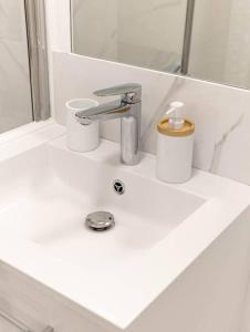 a bathroom sink with a faucet and two cups on it at Studio / 15min de la plage in Fréjus