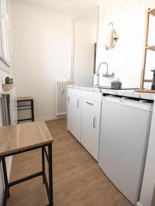 a white kitchen with a sink and a table at Studio / 15min de la plage in Fréjus