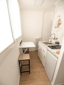 a small white kitchen with a sink and a table at Studio / 15min de la plage in Fréjus +9 photos