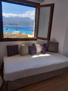 a bed in a room with a large window at Annissa Appartment in Karpathos