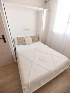 a small bed in a room with a window at Studio / 15min de la plage in Fréjus