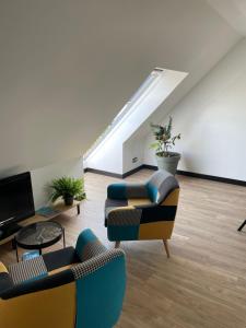 a living room with two chairs and a tv at appartement des mésanges 