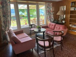 a living room with a couch and chairs and a table at Landhaus Strussnighof in Pörtschach am Wörthersee