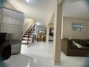 a living room with a couch and a staircase at Casa Azul Triplex in Cabo Frio