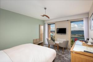 a bedroom with a bed and a desk and a television at Résidence Bellevue in Camaret-sur-Mer
