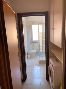 ein Bad mit einem WC, einem Waschbecken und einer Tür in der Unterkunft Casa al mare in Cogoleto