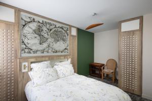 Résidence Bellevue في كاماريت-سور-مير: غرفة نوم بسرير كبير عليها لوحة جدارية