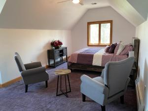 1 Schlafzimmer mit einem Bett, 2 Stühlen und einem Tisch in der Unterkunft Chestnuthill Countryside Manor in Effort