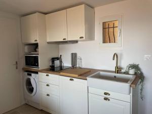 a kitchen with a sink and a washing machine at La Gaillardine T2+mezzanine 35m2 in Roquebrune-sur-Argens
