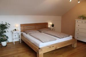 sypialnia z drewnianym łóżkiem z 2 poduszkami w obiekcie Ferienwohnung am Dreiseithof w mieście Hauzenberg