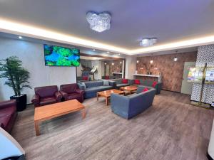 een grote woonkamer met banken en een flatscreen-tv bij Hotel Lido in Athene