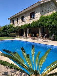 eine Villa mit einem Pool vor einem Gebäude in der Unterkunft Casa da Lomba Piscina y vistas al mar en Baiona in Baiona