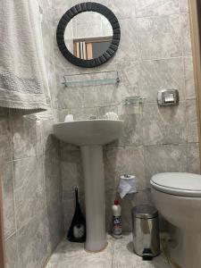 y baño con lavabo, aseo y espejo. en Casa Azul Triplex en Cabo Frío