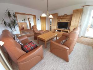 a living room with leather furniture and a television at Hubis Ferienwohnung in Olpe