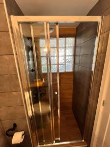 a glass shower in a bathroom with a window at Notos Sea Front Apartment in Glossa