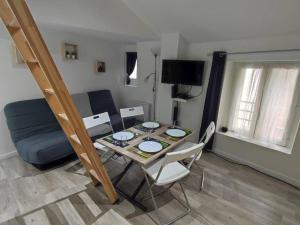 a small living room with a table and a couch at Little House : CDG-Paris-Asterix in Louvres