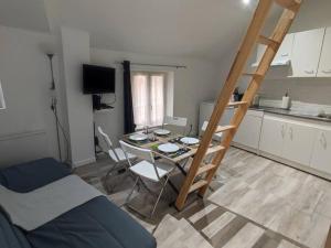 a room with a table and chairs and a kitchen at Little House : CDG-Paris-Asterix in Louvres