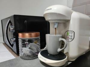 a coffee maker and a cup on a counter at Little House : CDG-Paris-Asterix in Louvres +13 photos