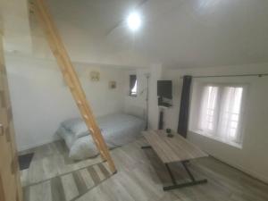 a room with a bed and a table and a window at Little House : CDG-Paris-Asterix in Louvres