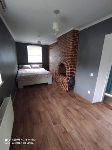 a bedroom with a bed and a brick fireplace at Casa Maria in Pohrebea