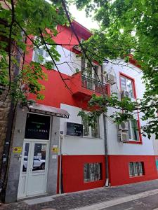 un bâtiment rouge et blanc avec une porte dans l'établissement Villa Nina Hotel & Lounge bar, à Skopje