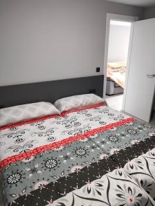una camera con un letto con una coperta bianca e nera di Apartamento Loft A Estivada Bajo a Rosal