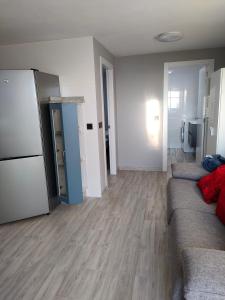 uma sala de estar com um sofá e um frigorífico em Apartamento Loft A Estivada Bajo em Rosal
