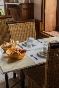 a table with plates and bowls of bread on it at Le Relais Des Templiers in Beaugency