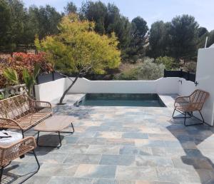 une terrasse avec 2 chaises et une piscine dans l'établissement Bord de mer + piscine, à Sausset-les-Pins