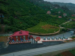 dom z czerwonym dachem obok drogi w obiekcie Lidzo Villa Butik Otel w mieście Trabzon
