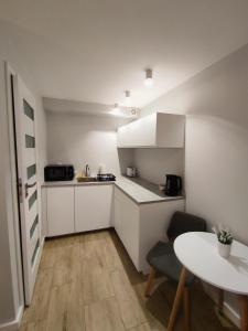 a small kitchen with white cabinets and a table at Apartament Joanna in Międzyzdroje