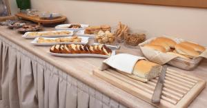 a table filled with different types of bread and pastries at Kronos Hotel in Heraklio Town