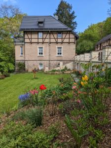 a house with a garden with flowers in front of it at Ferienwohnung Hartmann in Hohnstein