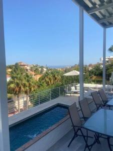 a swimming pool on a patio with chairs and a table at Appartement C dans une villa avec piscine chauffée & jacuzzi, chauffe en extra in Benalmádena