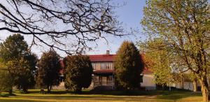 a house with a red roof and trees at Pärnu-Jaagupi pastoraat in Pärnu-Jaagupi