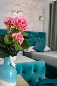a blue vase with pink flowers on a table at Hotel Boutique Andalucia in Fuengirola