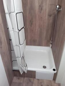 a small bathroom with a shower with a white tub at Chatka Andělka in Doksy