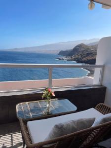 een balkon met een tafel en stoelen en de oceaan bij Blue relax Tabaiba in Tabaiba