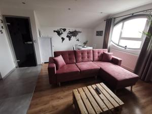 a living room with a pink couch and a table at Apartament Manhattan- KLIMATYZACJA in Słupsk +18 photos